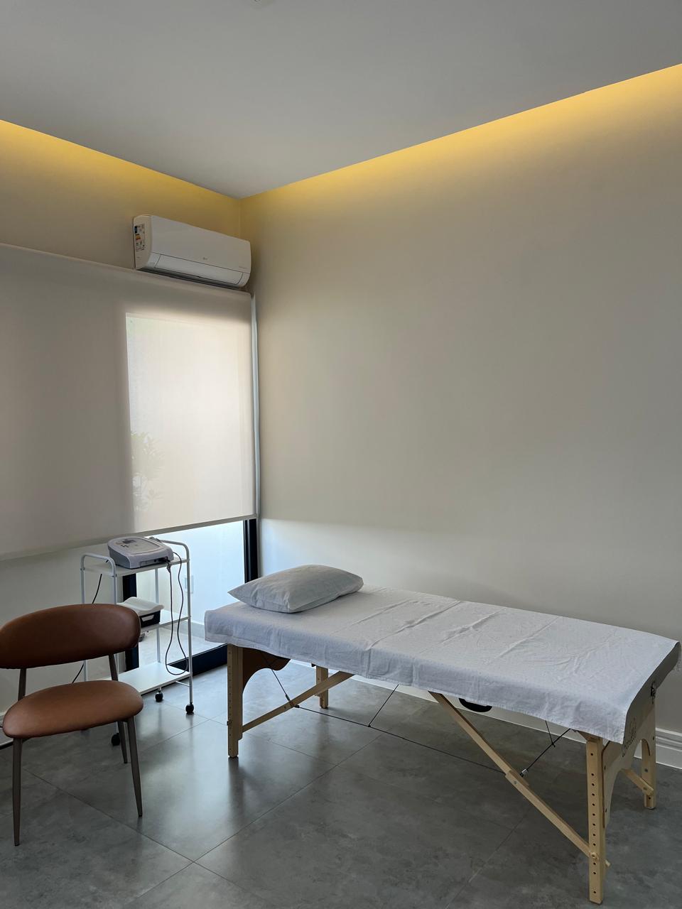 Sala de atendimento com maca, espaldar e espelho no Longevità Studio